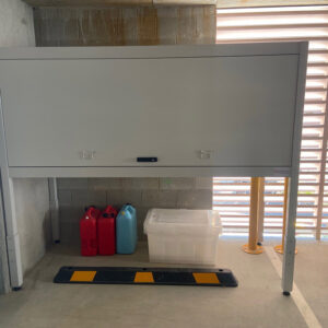 Compact storage cabinet for vehicles with safety barrier and containers.